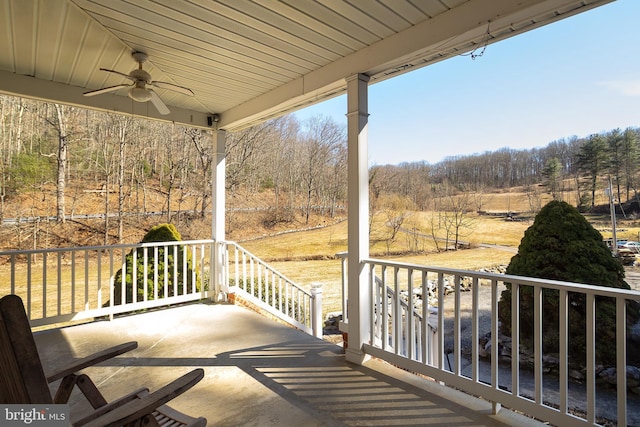 balcony with a porch and ceiling fan