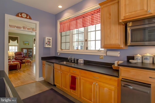 kitchen with stainless steel appliances, dark countertops, a sink, and recessed lighting