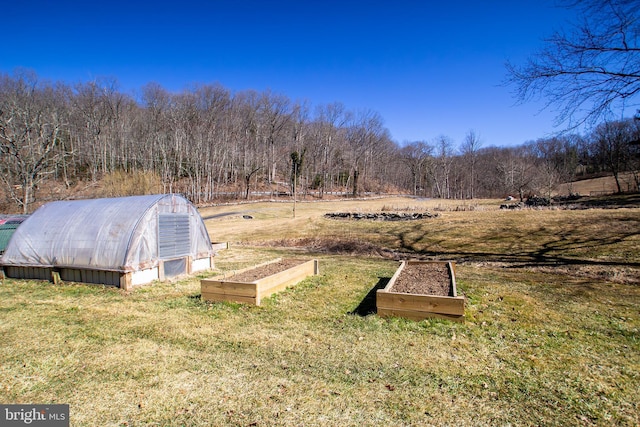 exterior space featuring an outbuilding, a rural view, an exterior structure, and a garden