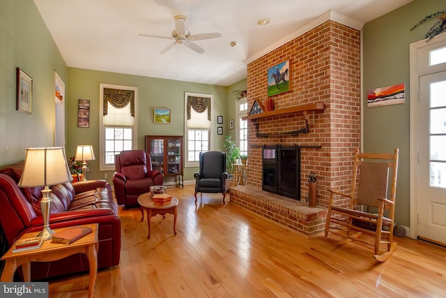 living room with a ceiling fan, baseboards, a fireplace, and hardwood / wood-style floors