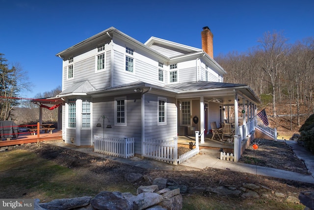 view of property exterior with covered porch and a chimney