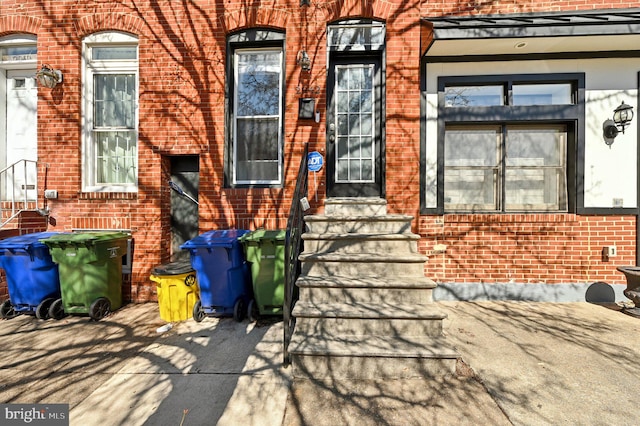 entrance to property featuring brick siding