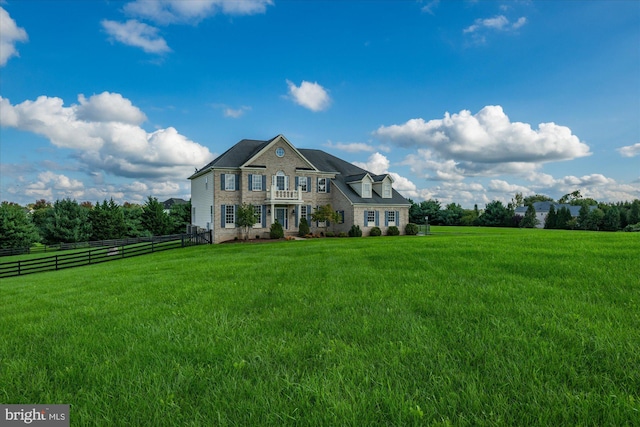 view of front of home featuring fence, a front lawn, and a rural view