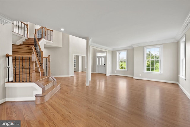 unfurnished living room featuring ornamental molding, stairs, baseboards, and wood finished floors