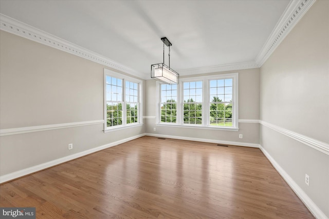 unfurnished dining area with ornamental molding, visible vents, baseboards, and wood finished floors