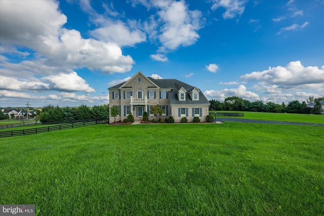 colonial inspired home with fence and a front lawn