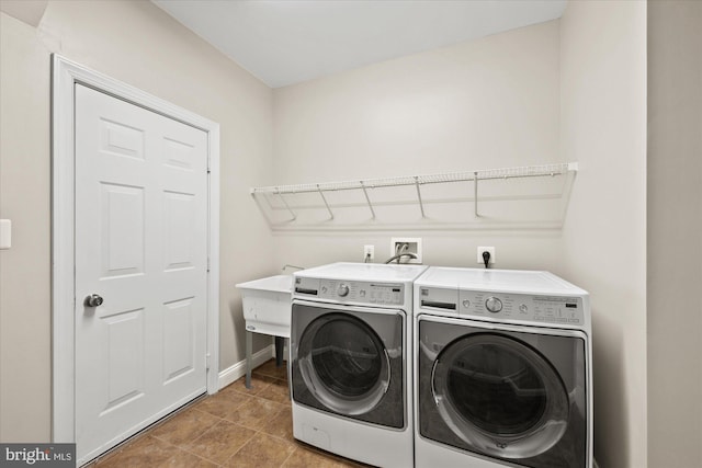 laundry room featuring laundry area, a sink, baseboards, and separate washer and dryer