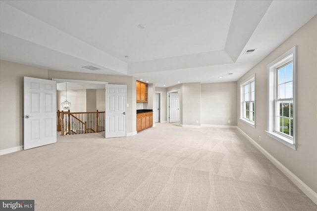 unfurnished living room featuring light carpet, visible vents, baseboards, and recessed lighting