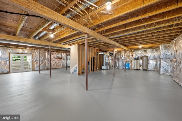 basement featuring stairway, gas water heater, and heating unit