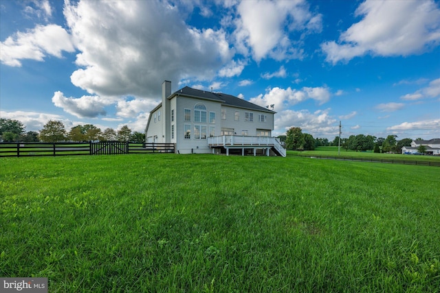 back of property featuring a lawn, a chimney, stairs, fence, and a wooden deck