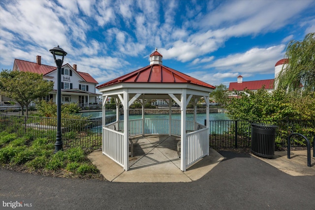 view of property's community featuring a gazebo, a water view, and fence