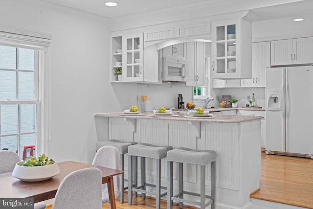 1733 Crestwood Dr, Alexandria, VA 22302 - kitchen with white appliances, white cabinetry, a peninsula, and a breakfast bar area