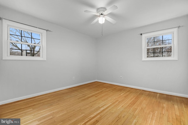 unfurnished room with baseboards, hardwood / wood-style floors, and a ceiling fan