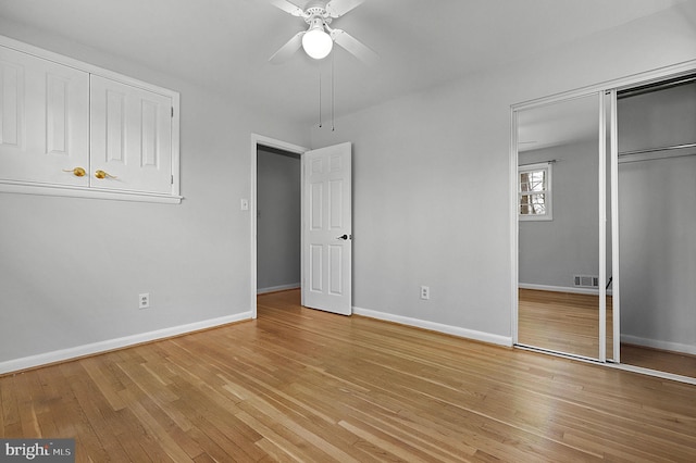 unfurnished bedroom featuring a closet, light wood-style flooring, baseboards, and ceiling fan