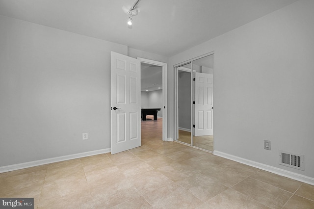 unfurnished bedroom with visible vents, baseboards, and a closet