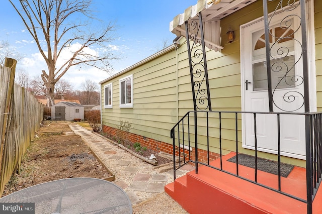 view of patio / terrace with an outbuilding, a shed, and fence