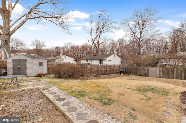 view of yard featuring a fenced backyard, an outbuilding, and a storage shed