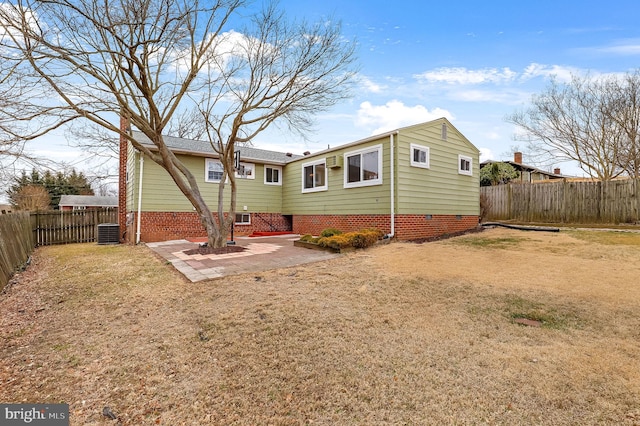 back of house with a patio, central air condition unit, a fenced backyard, and a lawn