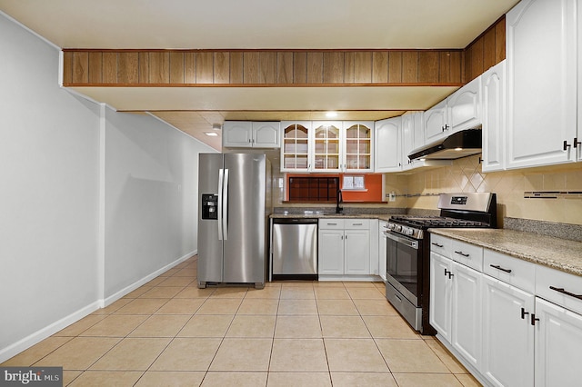 kitchen featuring light tile patterned floors, a sink, decorative backsplash, stainless steel appliances, and under cabinet range hood