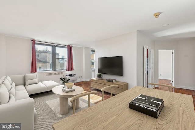 living area featuring radiator heating unit, baseboards, and wood finished floors