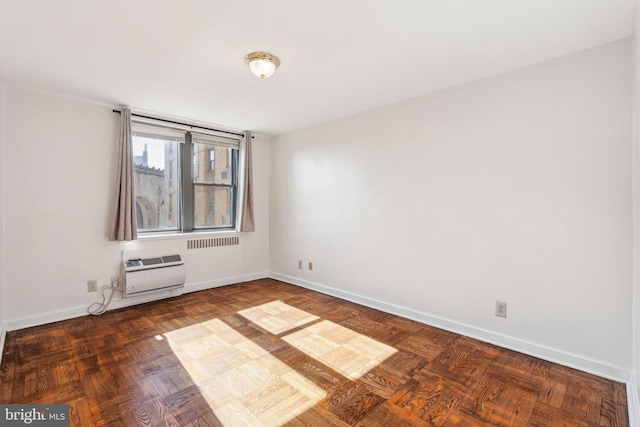 unfurnished room with a wall mounted AC and baseboards