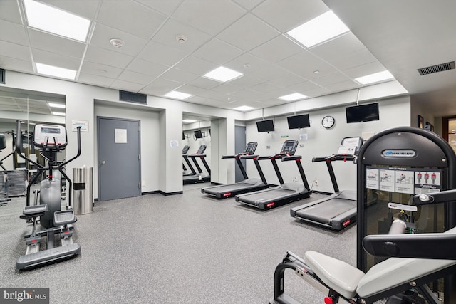 gym with a drop ceiling, visible vents, and baseboards