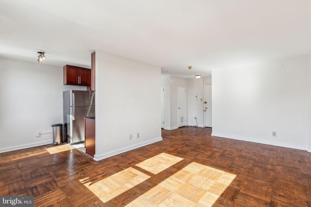 unfurnished living room featuring baseboards