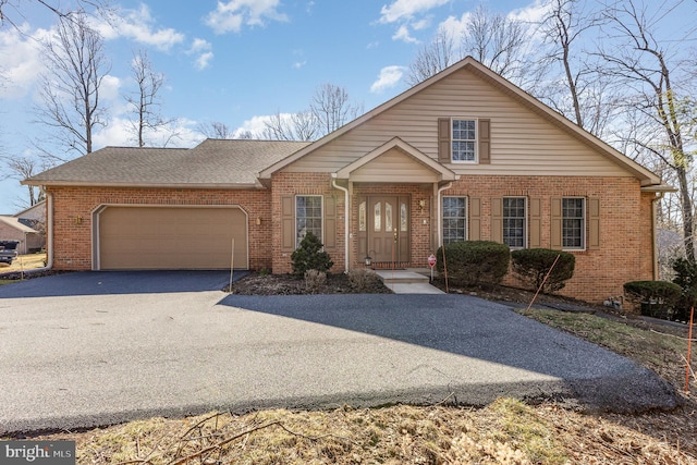 view of front facade with brick siding, a garage, driveway, and roof with shingles