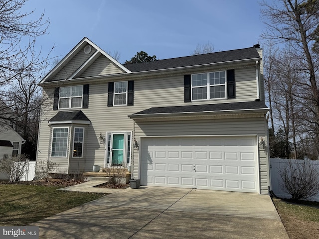 traditional-style house with an attached garage, concrete driveway, and fence