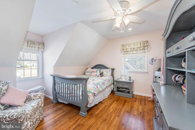 bedroom with a ceiling fan, vaulted ceiling, baseboards, and wood finished floors