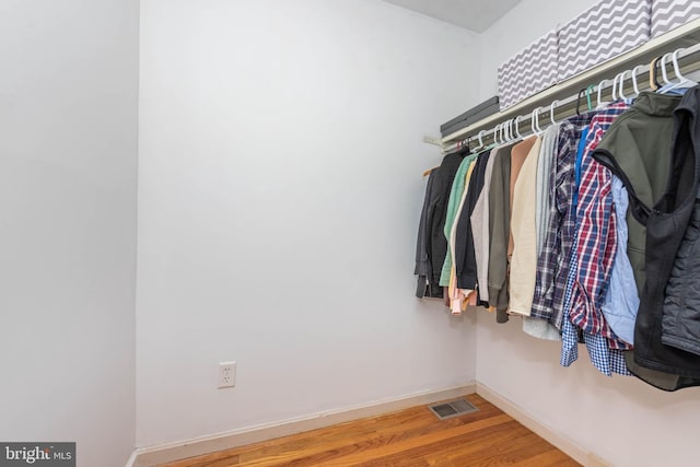 walk in closet with visible vents and wood finished floors