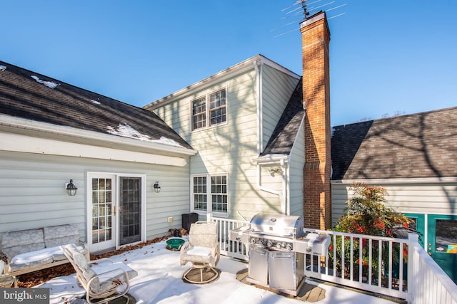 back of property featuring roof with shingles, a chimney, and a patio