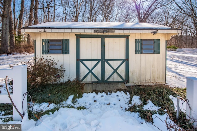 snow covered structure with a storage unit and an outdoor structure