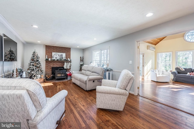 living room with recessed lighting, an AC wall unit, a textured ceiling, and wood finished floors