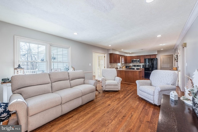 living room featuring a textured ceiling, wood finished floors, and recessed lighting