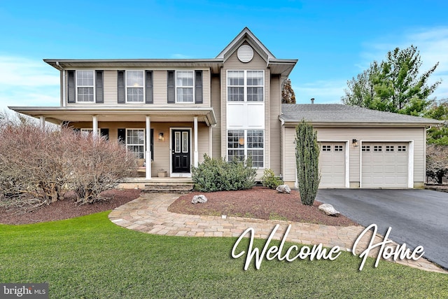 traditional-style home featuring an attached garage, covered porch, a front lawn, and aphalt driveway