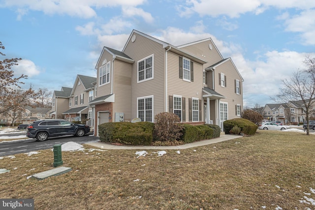 view of side of home featuring a garage, a residential view, and a lawn