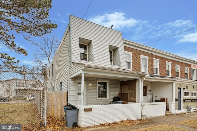 townhome / multi-family property with covered porch and fence