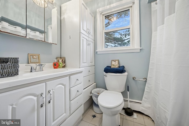 bathroom with toilet, vanity, baseboard heating, and tile patterned floors