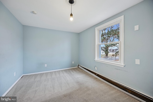 carpeted empty room featuring baseboard heating and baseboards