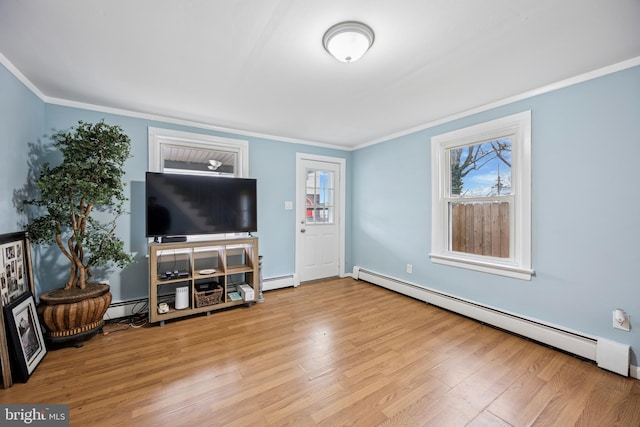 living room featuring a baseboard radiator, wood finished floors, and a wealth of natural light