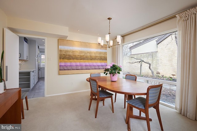 dining area featuring an inviting chandelier, plenty of natural light, baseboards, and light colored carpet