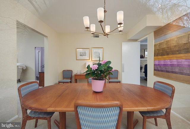 dining space featuring a fireplace and a notable chandelier