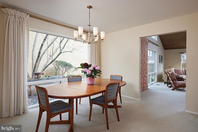 dining room with lofted ceiling, an inviting chandelier, baseboards, and light colored carpet