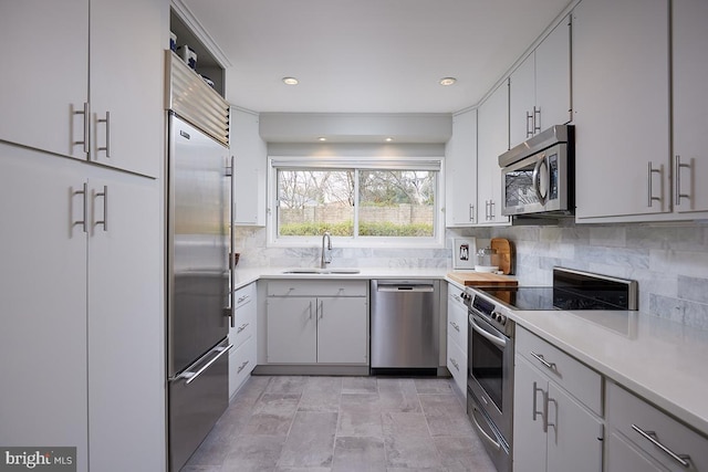 kitchen featuring appliances with stainless steel finishes, decorative backsplash, a sink, and light countertops