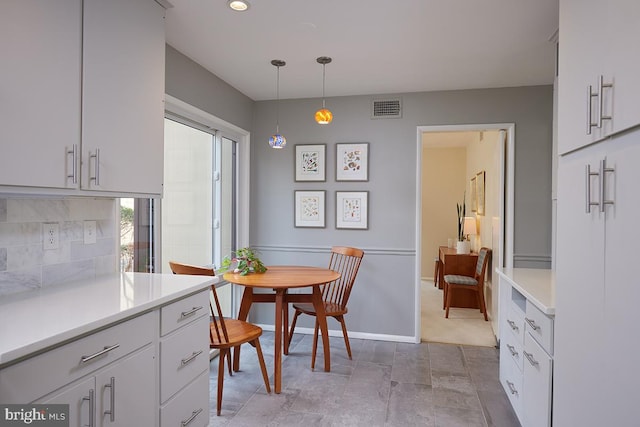 kitchen featuring light countertops, visible vents, backsplash, and white cabinetry