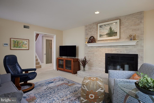 living room with stairs, a fireplace, visible vents, and carpet flooring