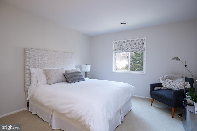 bedroom featuring baseboards, visible vents, and light colored carpet