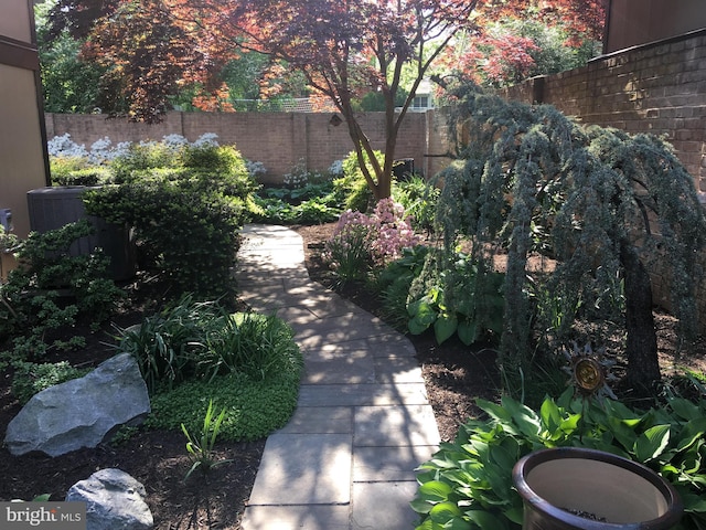 view of yard featuring fence and central air condition unit