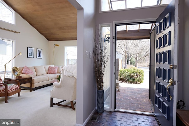 entrance foyer with brick floor, wood ceiling, and a high ceiling